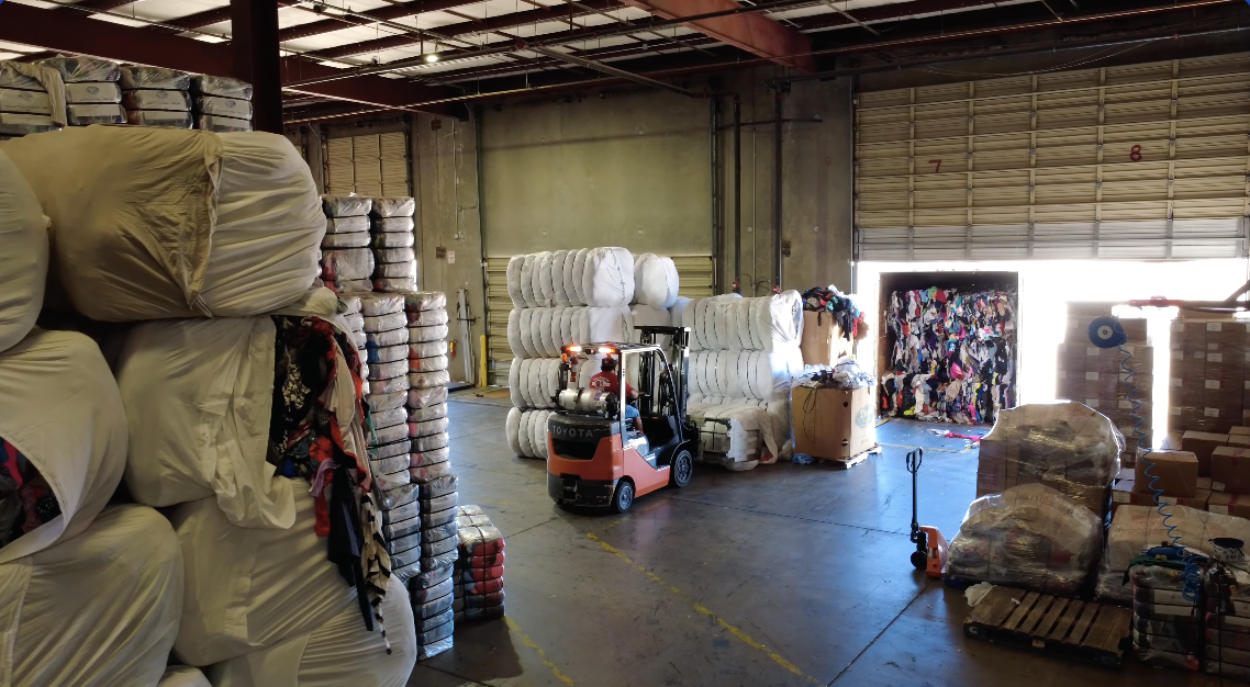 Warehouse interior with bales of used clothing and shoes ready for export